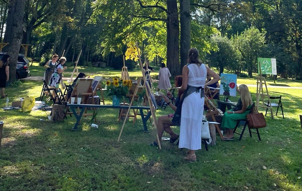Dalībnieki izbraukuma plenērā glezno savas izvēlētās ziedu kompozīcijas
